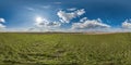 spherical 360 hdri panorama among green grass farming field with clouds on blue sky with sun in equirectangular seamless Royalty Free Stock Photo