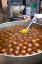 Spherical, not identified sweet deep fried balls floating in liquid. Indian street food Royalty Free Stock Photo