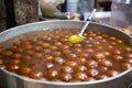 Spherical, not identified sweet deep fried balls floating in liquid. Indian street food Royalty Free Stock Photo