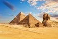 The Sphinx of Giza next to the Pyramids of Egypt and its companions in the sands of Giza desert, Egypt Royalty Free Stock Photo