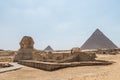 Sphinx with Pyramids in the the Giza pyramid complex, which includes the three Great Pyramids Khufu/Cheops, Khafre/Chephren and Royalty Free Stock Photo