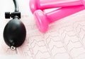 Sphygmomanometer, cardiogram and pink dumbbells Royalty Free Stock Photo