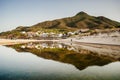 Front view from the beach of the village of Portixeddu with mountain in the background in a summer early morning. Royalty Free Stock Photo