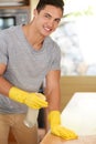 Spic and span. Portrait of a happy young man cleaning his kitchen. Royalty Free Stock Photo