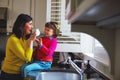 Spic, span and sparkling clean. a young mother and her daughter playing by the kitchen sink. Royalty Free Stock Photo