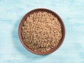 Spice cumin jeera in clay plate on blue background