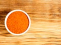 Spice red chili pepper powder in white bowl on brown wood background with copy space Royalty Free Stock Photo