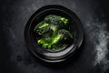 Spiced, boiled broccoli served on a dish. the color black looking up. Copy space