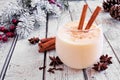Spiced Christmas eggnog close up on a rustic white wood