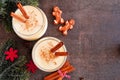 Spiced Christmas eggnog. Top view scene on a dark stone background.