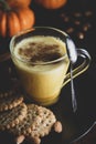 Spiced golden milk pumpkin autumn latte drink milkshake with cream foam dark black background