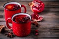 Spiced Pomegranate Apple Cider Mulled Wine Sangria in red mugs on wooden background. Royalty Free Stock Photo