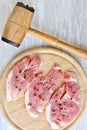 Spiced raw pork chop and hammer for beating meat Royalty Free Stock Photo