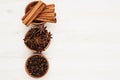 Spices - aniseed, cinnamon, cloves in wooden bowls on a wood white background.