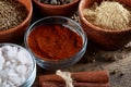 Spices in ceramic and glass bowls on the top of wooden barrel, close-up, selective focus.