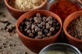 Spices in ceramic and glass bowls on the top of wooden barrel, close-up, selective focus.