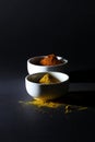 Spices in cups on a black background