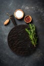 Spices and herbs with craft cutting board at black background. Royalty Free Stock Photo
