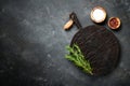 Spices and herbs with craft cutting board at black background. Royalty Free Stock Photo