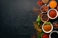 Spices and herbs on a wooden board. Pepper, salt, paprika, basil, turmeric. On a black wooden chalkboard. Royalty Free Stock Photo