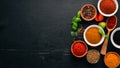 Spices and herbs on a wooden board. Pepper, salt, paprika, basil, turmeric. On a black wooden chalkboard. Royalty Free Stock Photo