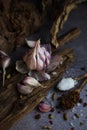 Spices, pepper peas, salt and pieces of pepper wigs on the table. Big garlic on a wooden stand Royalty Free Stock Photo