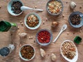 Spices, seasonings from dried vegetables, chickpeas and other grains in plates and banks on a wooden table. Background with spices