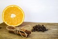 Spices and sliced fresh orange on an old wooden cutting board. Ripe orange, Cinnamon sticks and cloves on wooden background, close Royalty Free Stock Photo