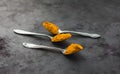 Spices turmeric in a spoon on a dark background