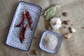 Spices, white, black and red peppers, sea salt, garlic and chilli on a rustic linen background, close-up Royalty Free Stock Photo