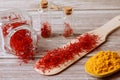 Spices on a wooden background. Saffron and turmeric on a wooden spoon