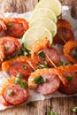 Spicy appetizer of shrimp with chorizo on skewers and herbs closeup. vertical Royalty Free Stock Photo