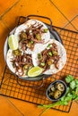 Spicy Beef Barbacoa Tacos with Cilantro and Onion. Orange background. Top view