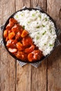 Spicy beef cooked with apples in tomato sauce with rice side dish close-up on a plate. Vertical top view Royalty Free Stock Photo