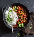 Spicy beef with vegetables and rice in a cast iron skillet on a dark background, top view Royalty Free Stock Photo