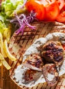 Spicy bifteki, frikadelle or frikkadel meatballs with minced beef and lamb with pita bread, tzatziki dip, vegetables salad and Fre Royalty Free Stock Photo