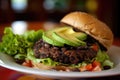 Spicy black bean burger, with patty made of black beans, corn, and spices, topped with salsa, avocado and lettuce on a Royalty Free Stock Photo