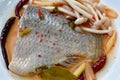 Spicy boiled Tilapia or mango fish tail with shimaji mushroon in tom yum soup on plate Royalty Free Stock Photo