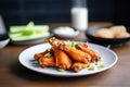 spicy buffalo wings on a plate with celery sticks Royalty Free Stock Photo