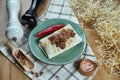 Spicy burrito or shawarma on a blue plate with traditional boiled, soft beef in a composition with spices. Close up view. Food