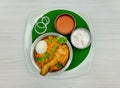 Spicy chicken biriyani with egg, raita, sauce and onion on banana leaf on grey back ground top view indian, pakistani food Royalty Free Stock Photo