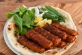 Spicy Chicken kabab meat seekh kebab with bahraini bread tandoori nan, lime and salad served in dish isolated on wooden table top Royalty Free Stock Photo