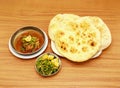 Spicy chicken korma khamiri roti, lemon slice and salad served in a dish isolated on wooden table side view of indian, pakistani