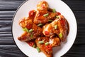 Spicy chicken wings in teriyaki sauce served with green onions and chili pepper close-up on a plate. horizontal top view Royalty Free Stock Photo