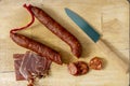 Spicy chorizo typical of Spain, chopped with a knife and a few slices of ham on the side Royalty Free Stock Photo