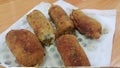 Spicy and delicious croquettes served in ceramic plate over wooden floor