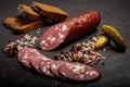 Spicy dry cured salami sausage with rye bread and pickled cucumbers Royalty Free Stock Photo