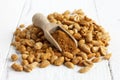 Spicy dry roasted peanuts on white with wood scoop. Royalty Free Stock Photo