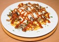 Spicy fast food: French fries with cheddar cheese, chili and chicken fillet, close-up sauce on a plate. Background Royalty Free Stock Photo