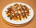 Spicy fast food: French fries with cheddar cheese, chili and chicken fillet, close-up sauce on a plate. Background Royalty Free Stock Photo